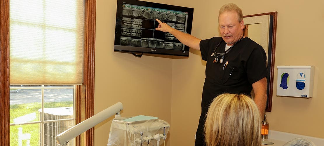 Dr. Guebert looking at dental x rays with a patient